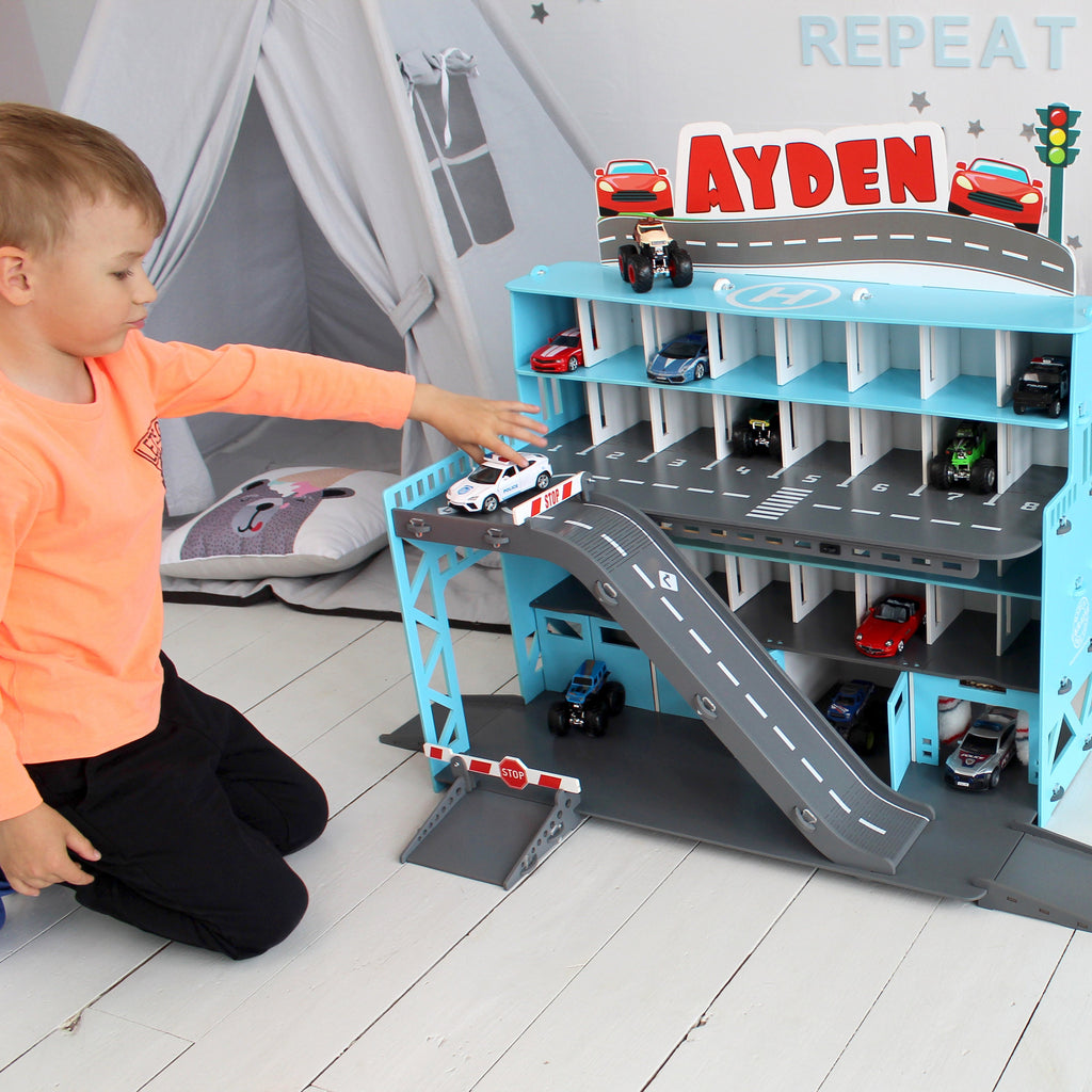toddle boy plays with his toy car garage