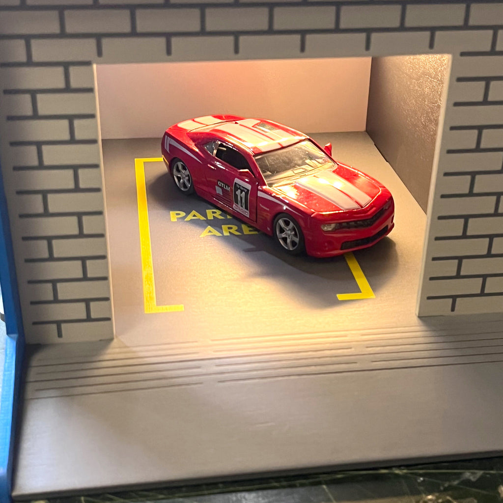 Toy garage with sectional roll-up doors and garage door opener, toy car storage, toy car service station
