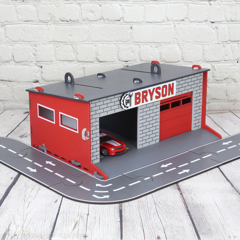 Toy garage with sectional roll-up doors and garage door opener, toy car storage, toy car service station