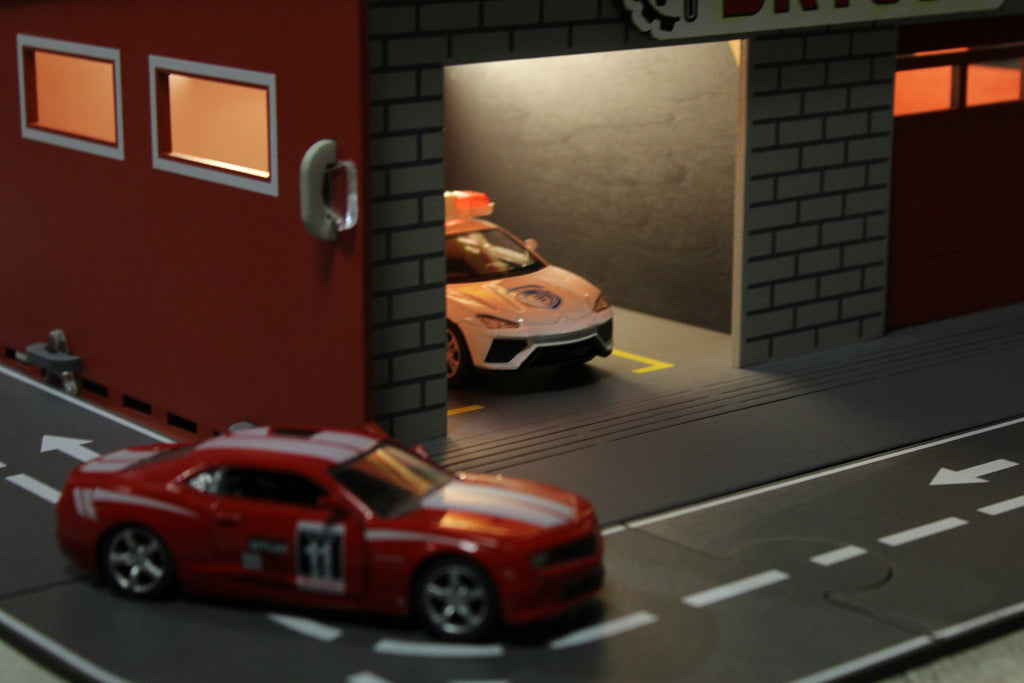 Toy garage with sectional roll-up doors and garage door opener, toy car storage, toy car service station