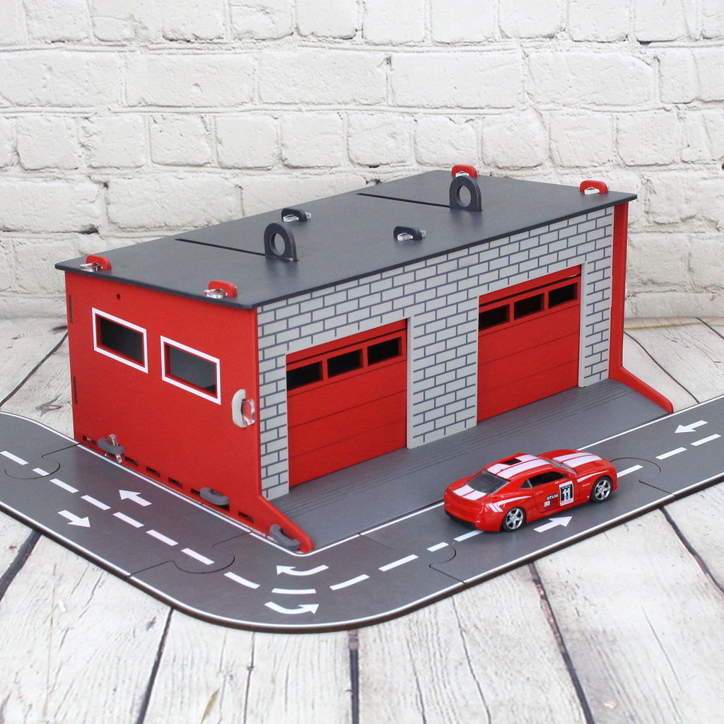 Toy garage with sectional roll-up doors and garage door opener, toy car storage, toy car service station