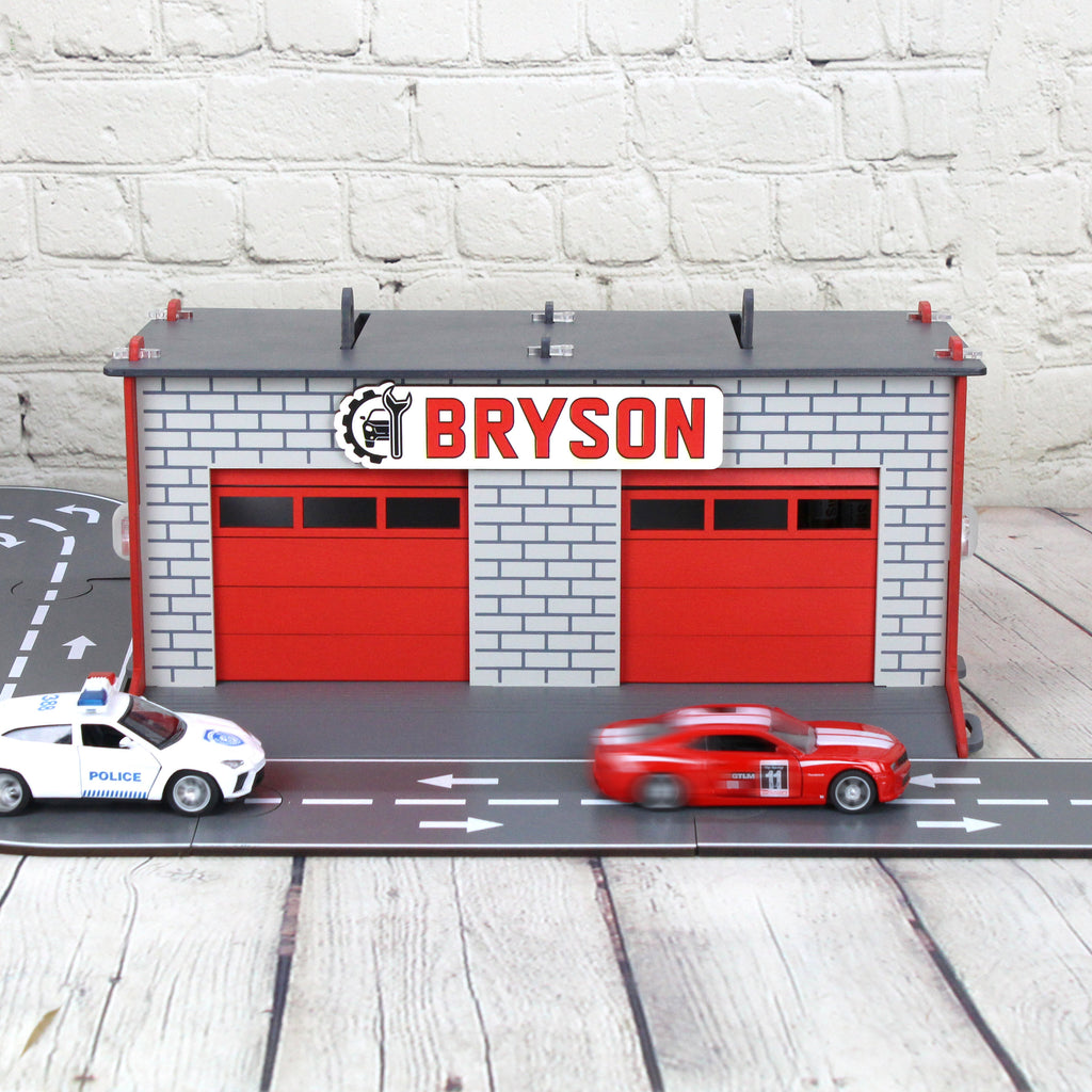 Toy garage with sectional roll-up doors and garage door opener, toy car storage, toy car service station