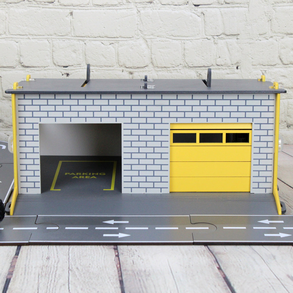 Toy garage with sectional roll-up doors and garage door opener