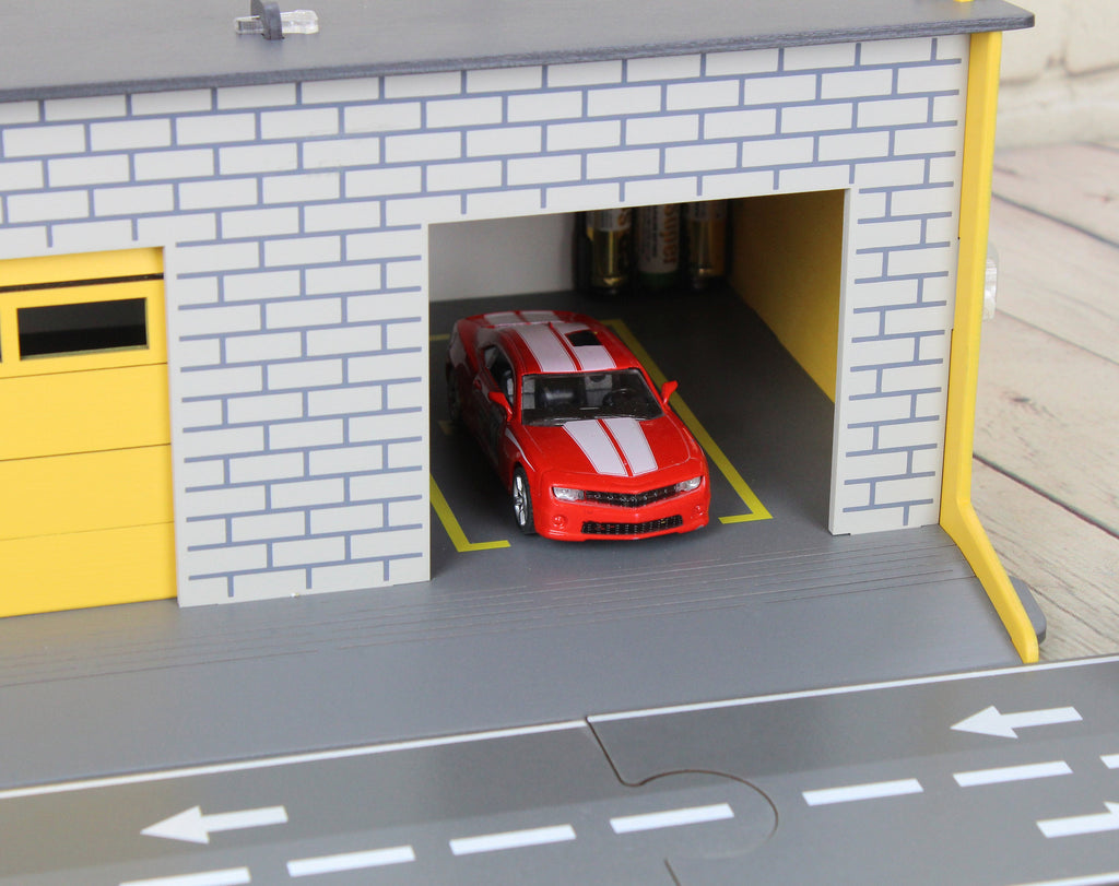 Toy garage with sectional roll-up doors and garage door opener
