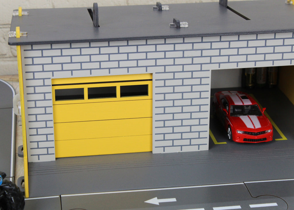 Toy garage with sectional roll-up doors and garage door opener